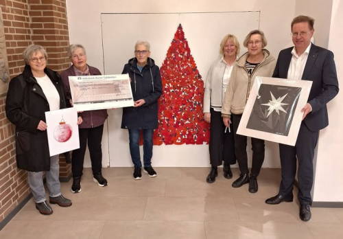 v. l.: Barbara Hattrup (Künstlerin), Hildegard Beine (Eine Welt Laden), Karin Schmidt (Speisenkammer Salzkotten), Monika Werner (Stadtmarketing), Annette Breische (Pastoralverbund Salzkotten) und Bürgermeister Ulrich Berger vor einem roten Weihnachtsbaum, der im Rahmen des Projekts entstand und im Foyer des Rathauses hängt